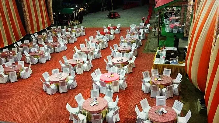 Looking down on round tables set with white chairs on the lawn