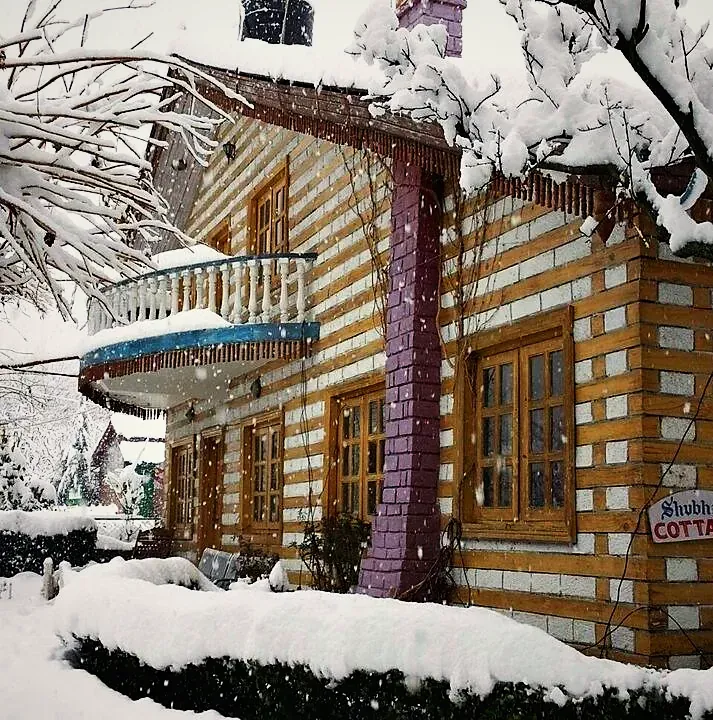 A timber cottage covered in fresh snow