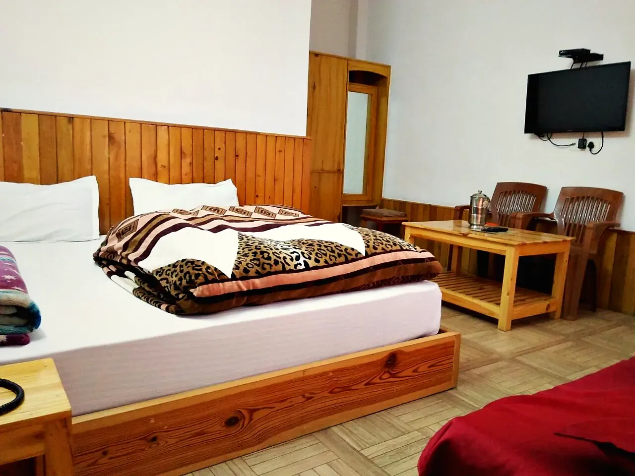 A double room with a sitting area and wall-mounted television